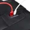 Близък план на външен USB порт на раница за пътуване STELS CityPro 30, с включен кабел за зареждане.